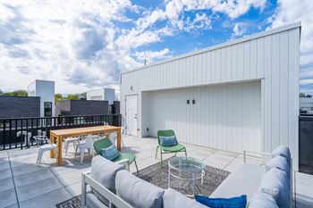 a patio with a couch and chairs and a table at Matilda 235 Townhomes, Des Moines